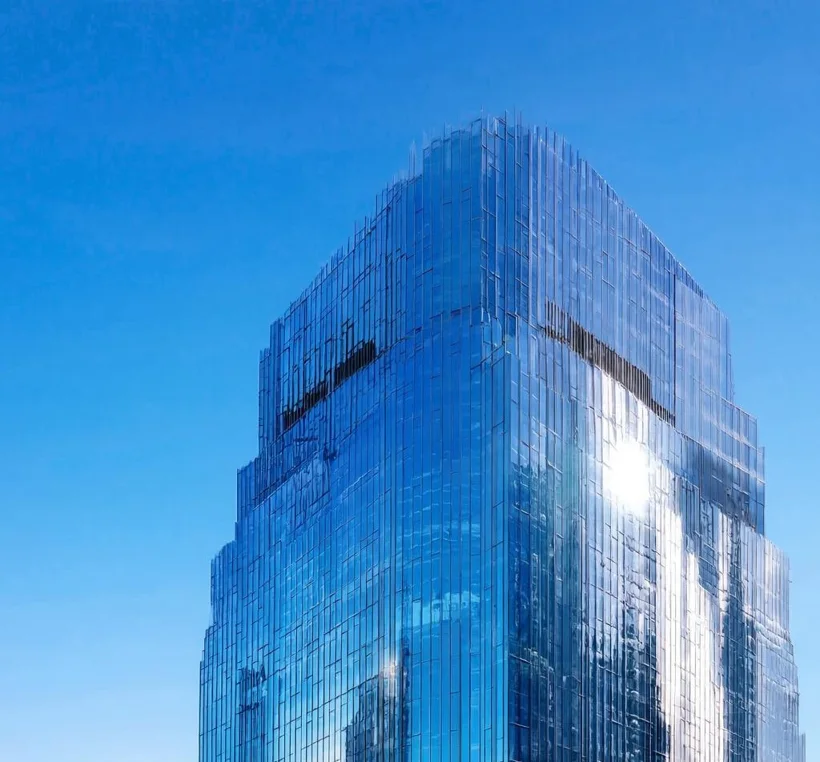 Corporate glass office tower viewed from below against the sky